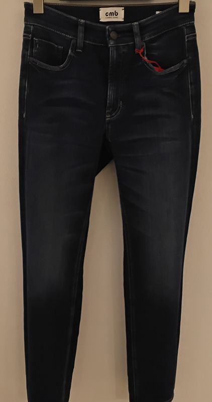 Dunkelblaue Jeans auf einem Kleiderbügel, leicht ausgeblichen, rote Nähte sichtbar.