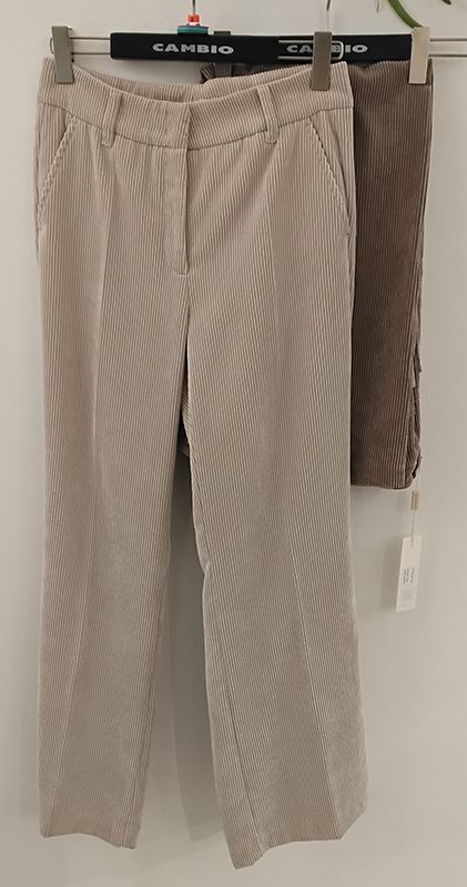 Beige Cordhosen hängen an einem Kleiderständer.