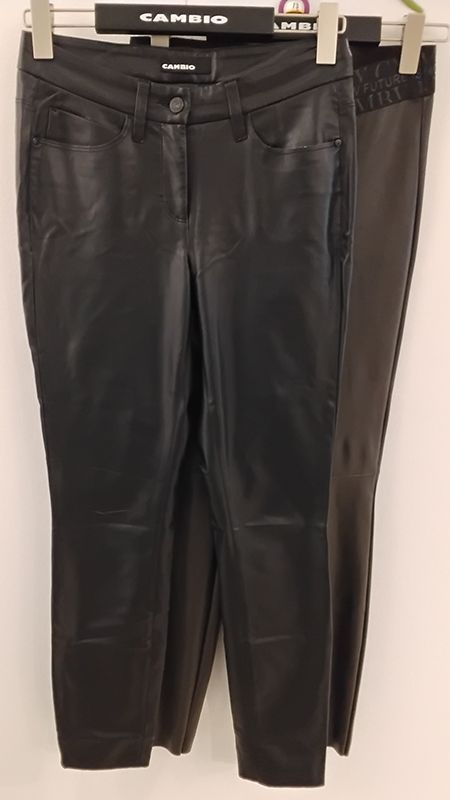 Schwarze Lederhosen hängen an einem Kleiderständer.