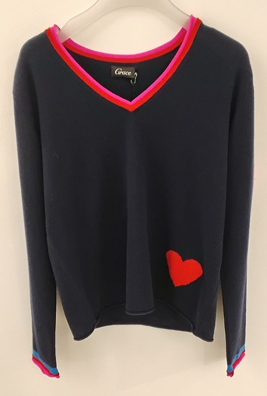 Marineblauer Pullover mit V-Ausschnitt und rotem Herz, rosa/rotem Besatz an Ausschnitt und Bündchen.