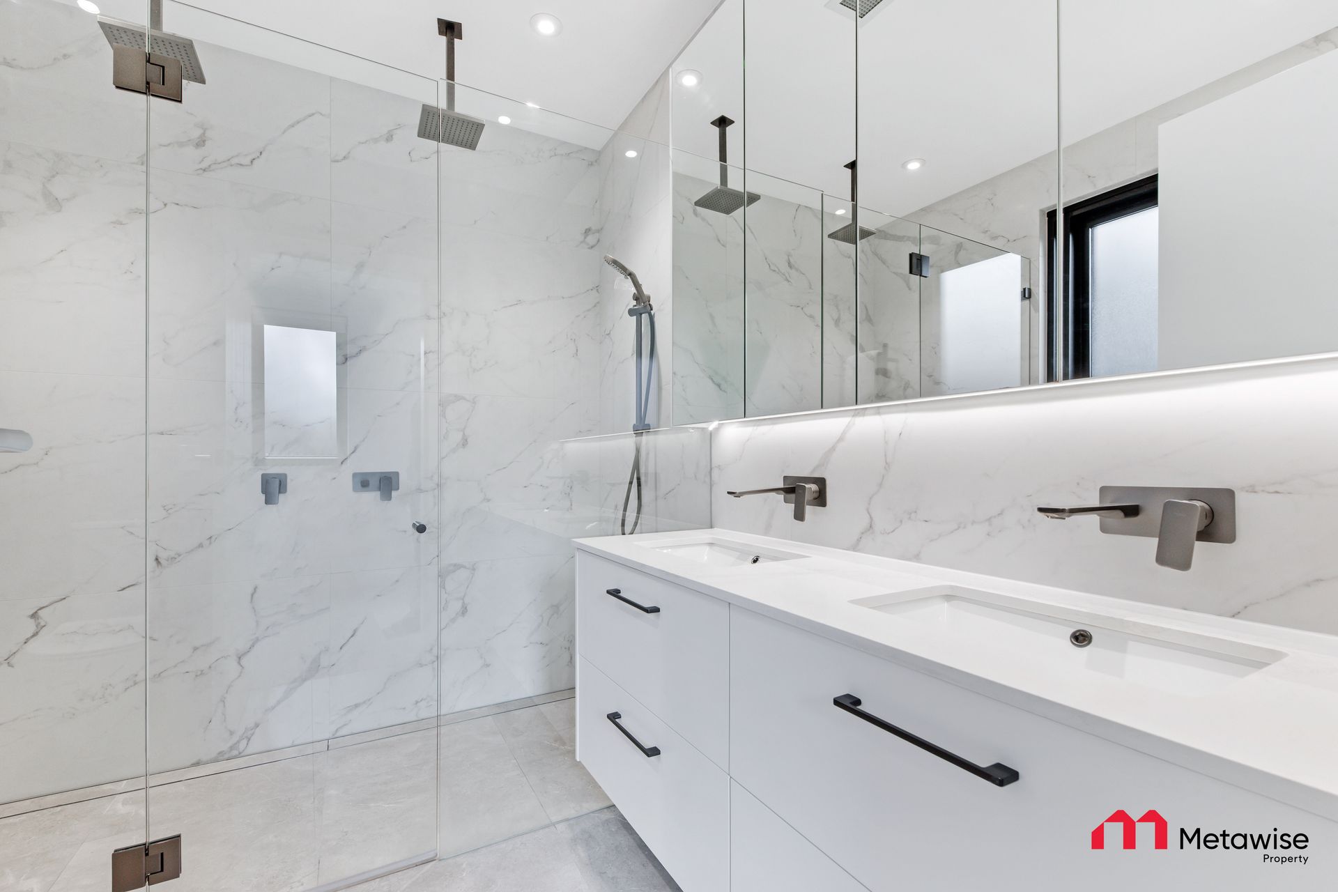 A bathroom with a sink , mirror and shower.