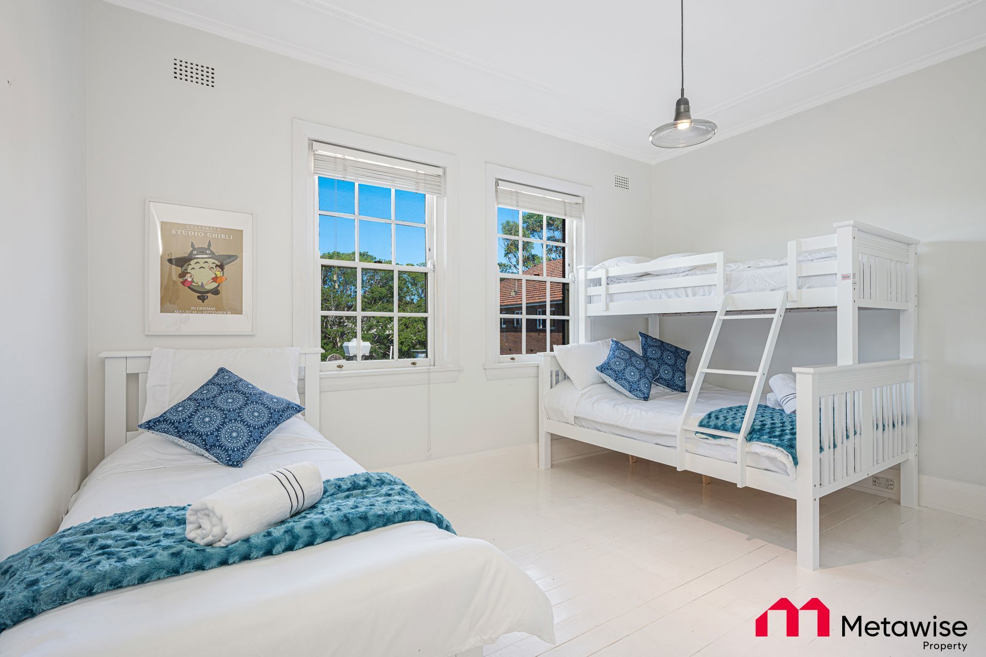 A bedroom with two bunk beds and a single bed.