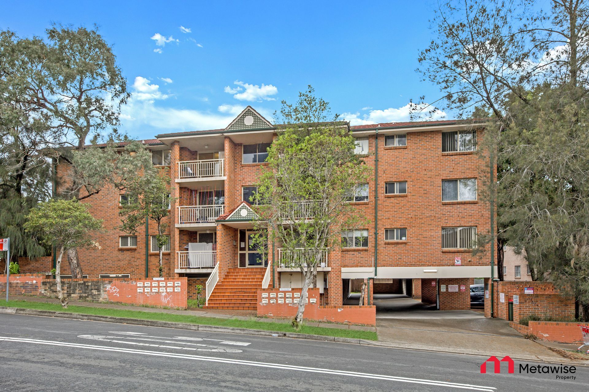 A large brick apartment building with trees in front of it