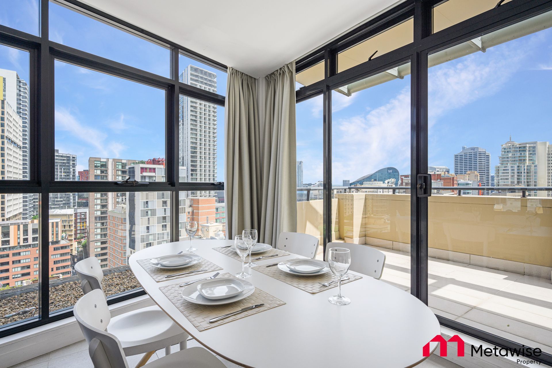 A dining room with a table and chairs and a view of the city.