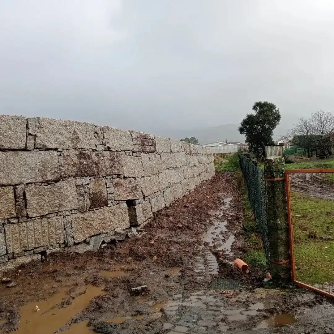 Un alto muro de contención de piedra se alza 