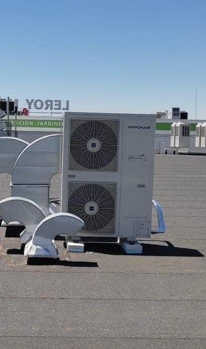 Unidad de aire acondicionado de techo blanco sobre un techo plano con cielo