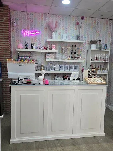 Mostrador de venta al por menor blanco en un salón de uñas con estanterías que exhiben productos