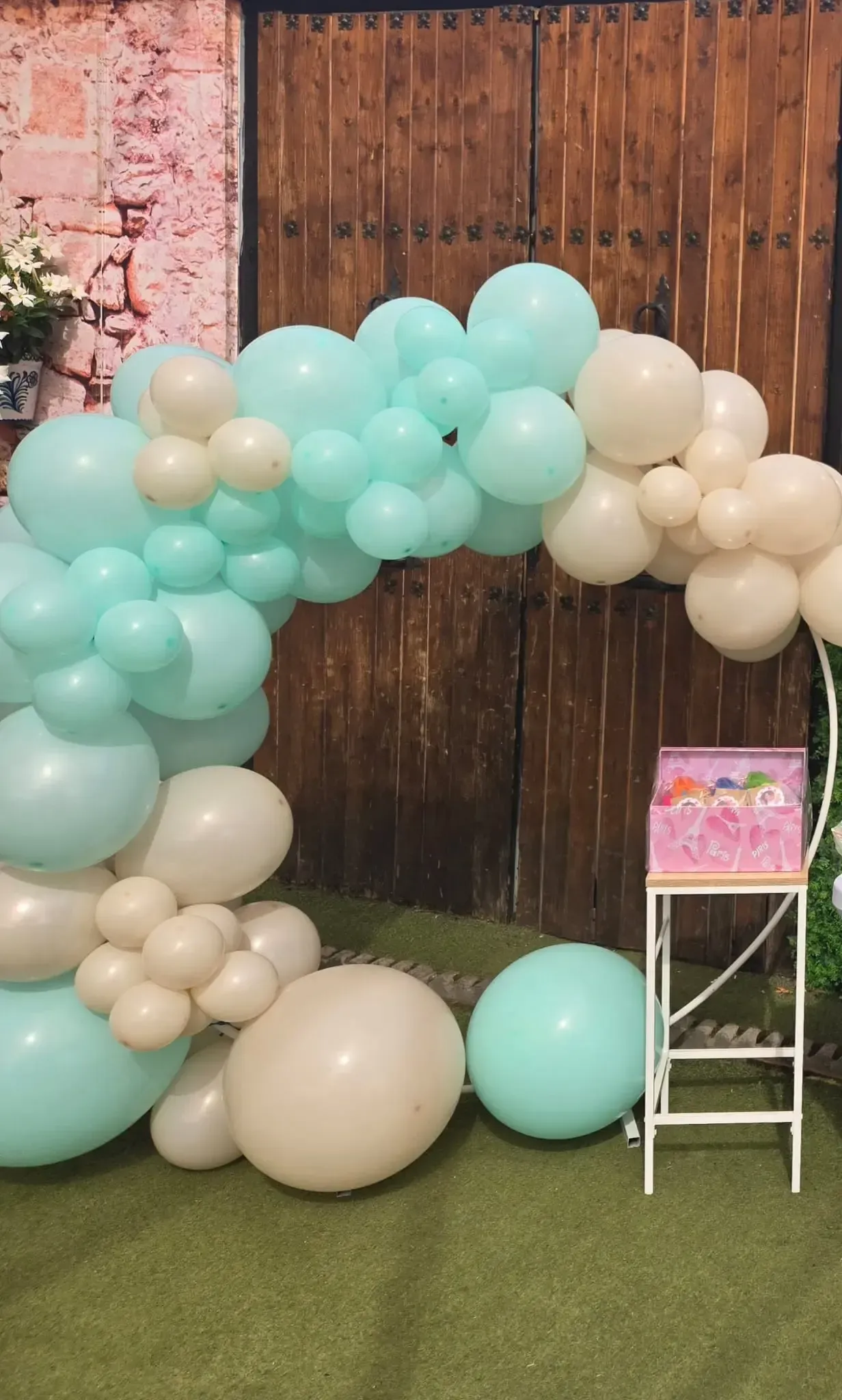 Una mesa de delicias con temática de fútbol: dulces, pasteles y frascos decorados, sobre un mantel claro.
