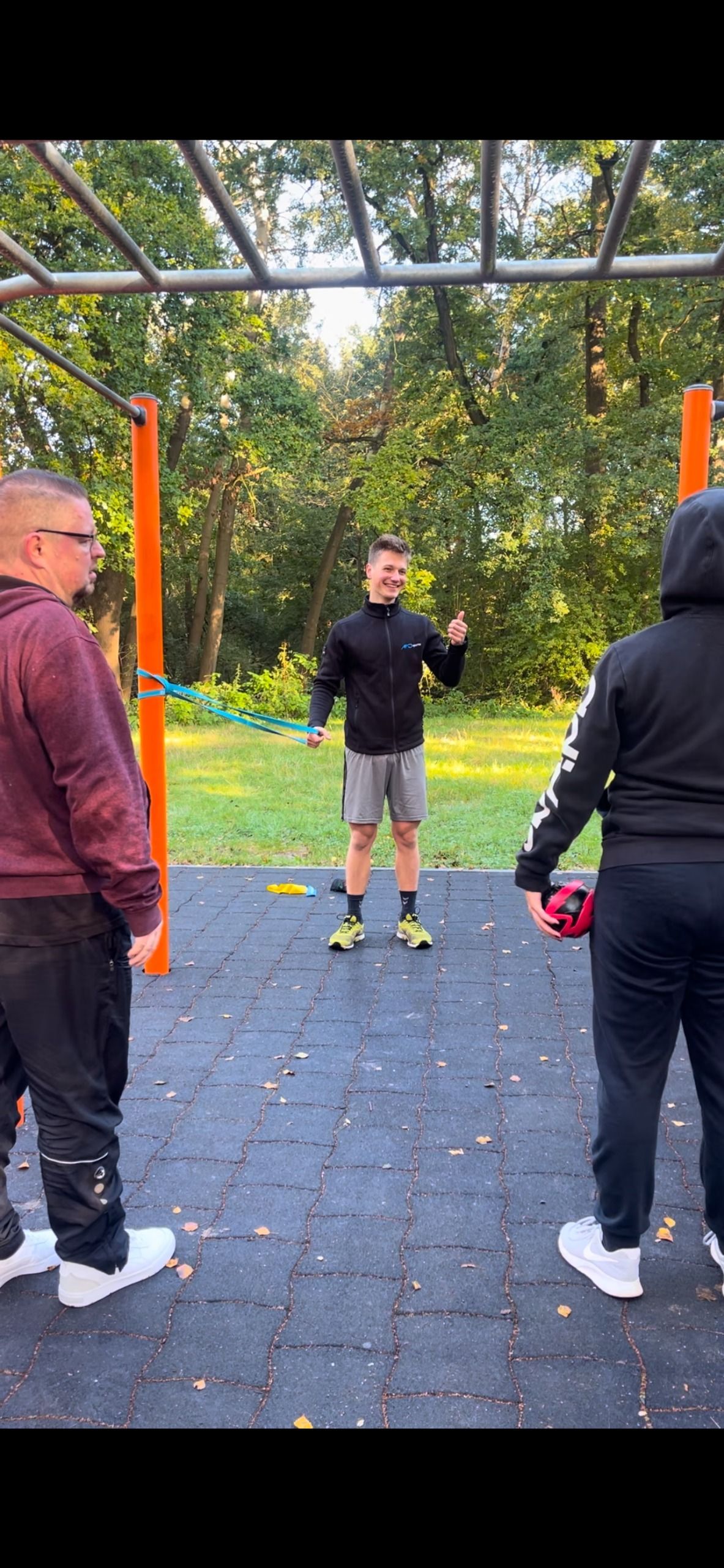 Eine Gruppe von Männern steht nebeneinander in einem Park.