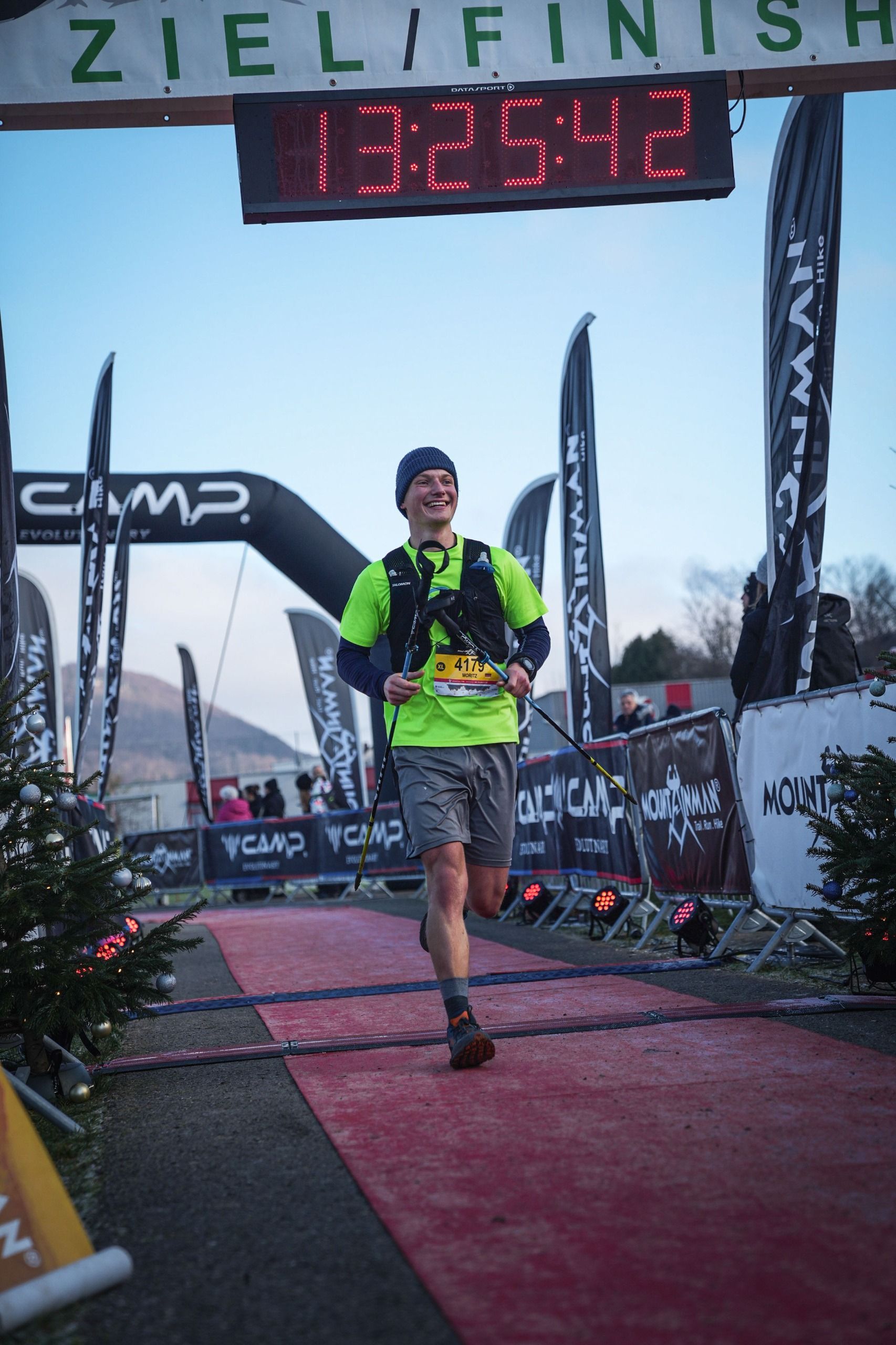 Ein Mann läuft auf einem roten Teppich vor einer Digitaluhr vorbei.