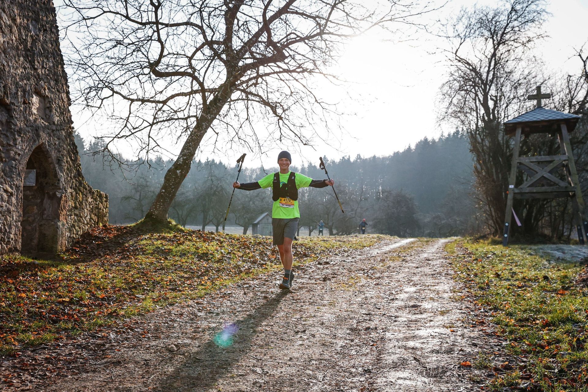 Ein Mann läuft auf einem Feldweg im Wald.