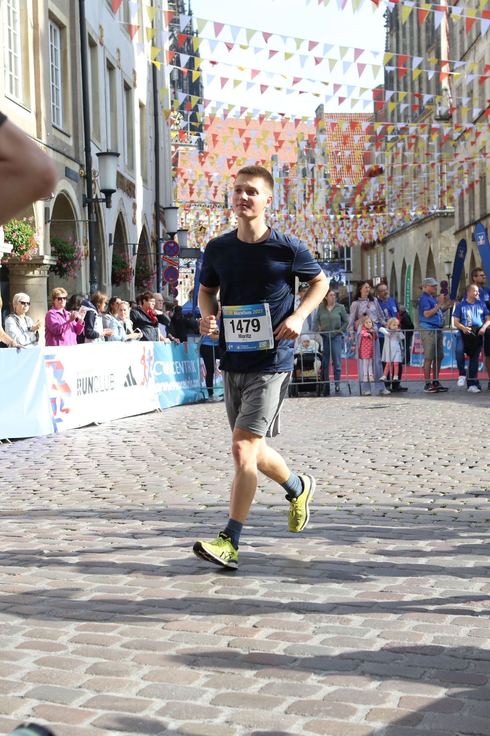 Ein Mann rennt eine Kopfsteinpflasterstraße entlang.