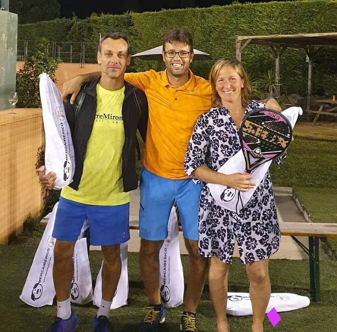 Tres personas con ropa deportiva celebrando al aire libre. Una mujer y dos hombres sonriendo.