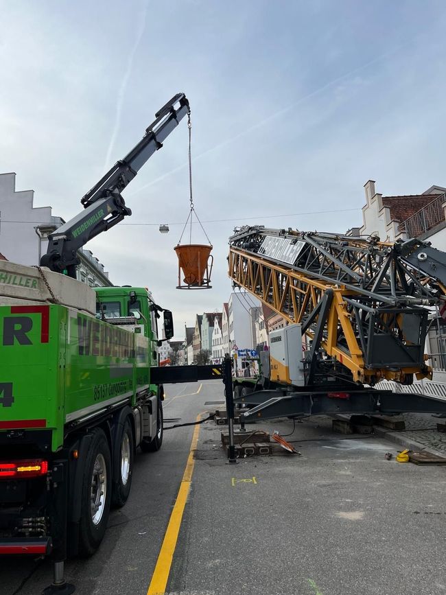 Montage eines Untendreher-Baukrans in Ingolstadt durch einen mobilen Autokran vor blauem Himmel mit Schleierwolken