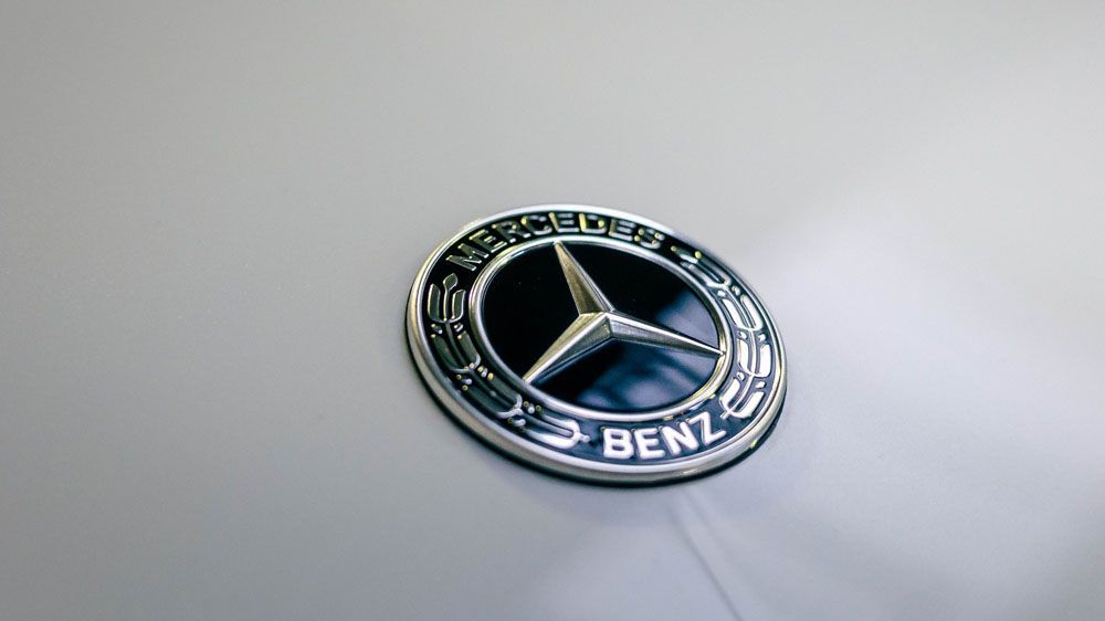 Eine Nahaufnahme eines Mercedes-Benz-Logos auf einem Auto.