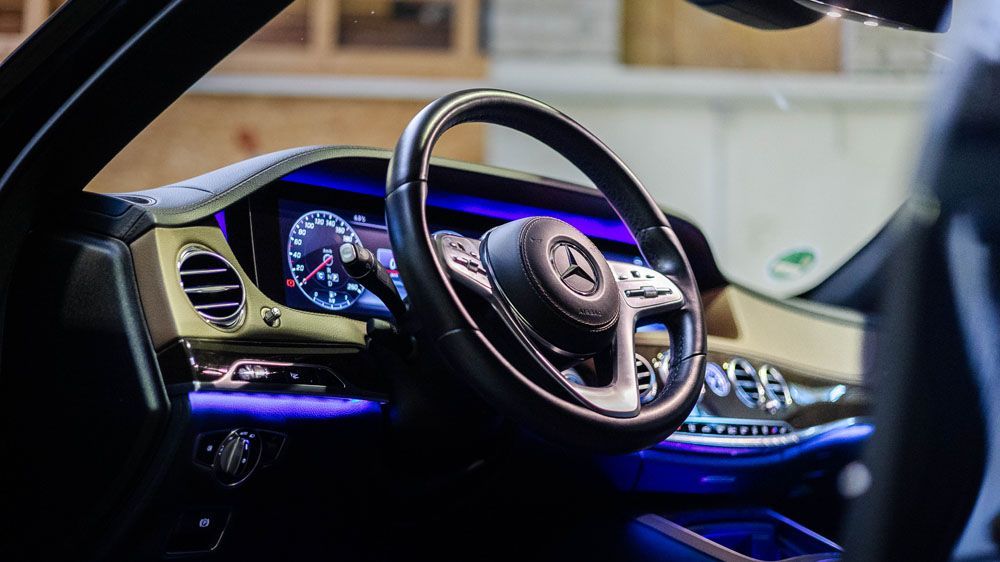 Eine Nahaufnahme vom Lenkrad und Armaturenbrett eines Autos.