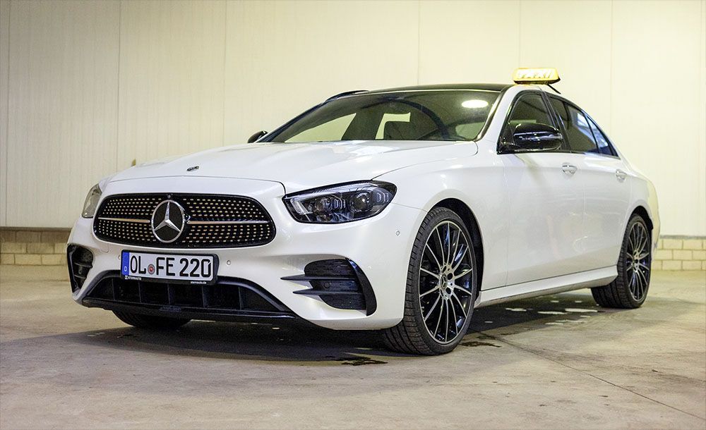 Ein weißer Mercedes Benz steht auf einem Parkplatz.