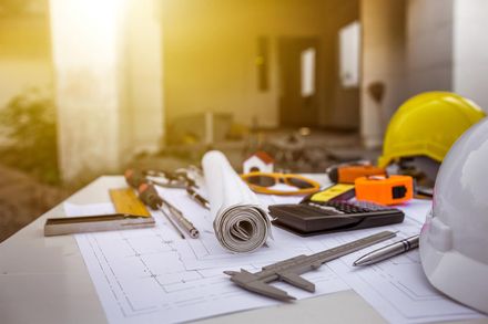 Un casco está sobre una mesa con herramientas de construcción.