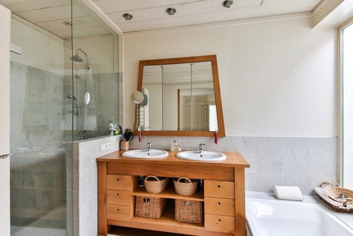 Salle de bains avec un miroir au dessus d'un meuble