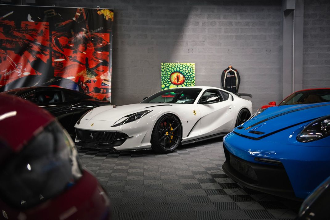 Voitures de luxe dans une salle d'exposition, avec une voiture de sport blanche au centre