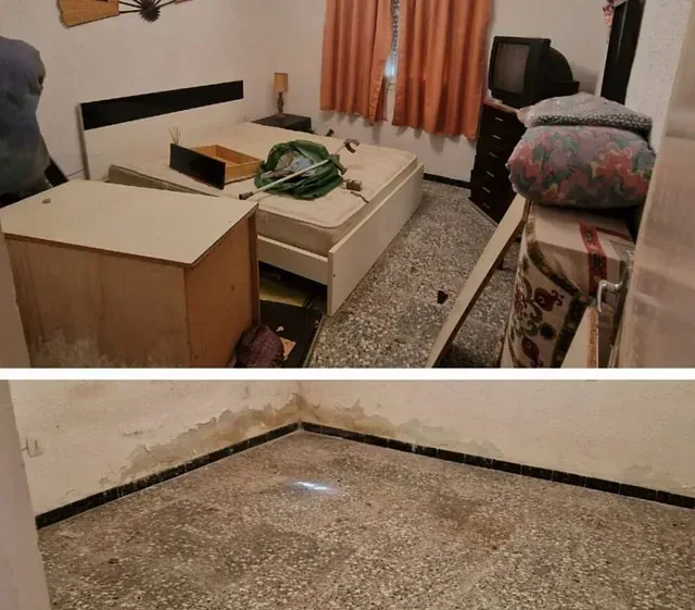 Un dormitorio con una cama y un televisor en la pared.