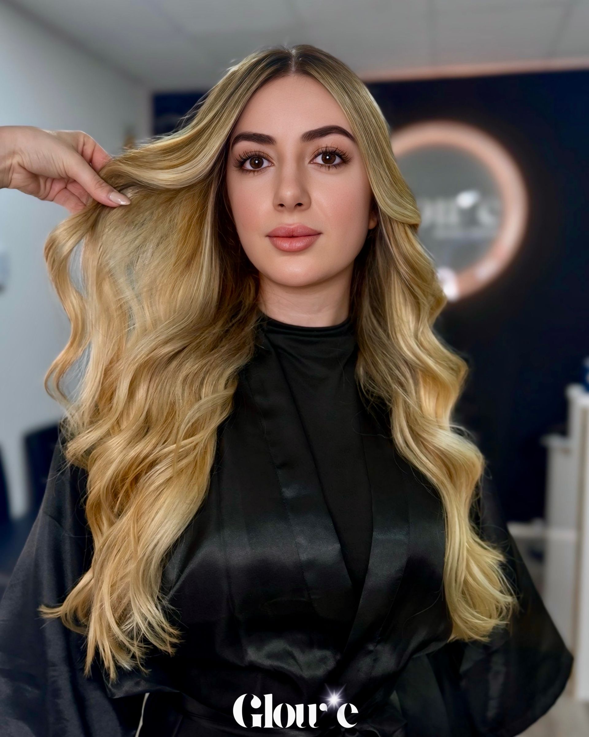 Una mujer con cabello largo y rubio lleva un top corto negro.