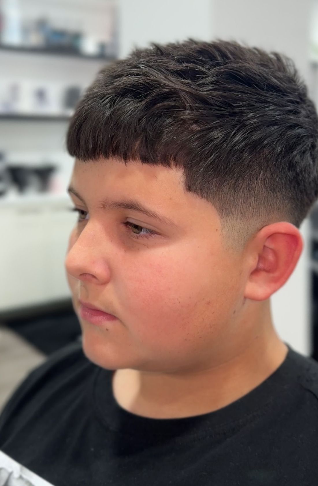 Un joven se está cortando el pelo en una barbería.