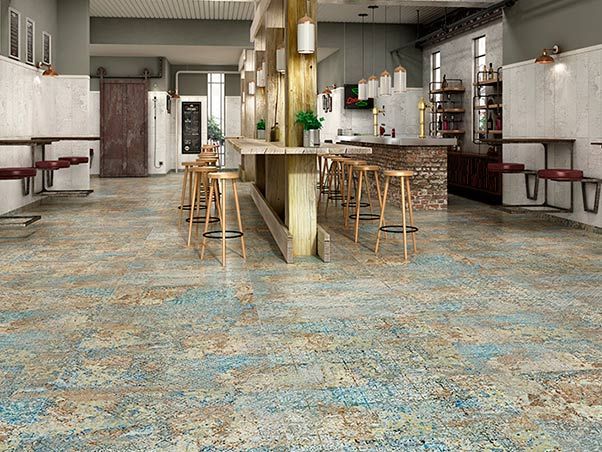 Un restaurante con mesas y taburetes y suelo de baldosas.