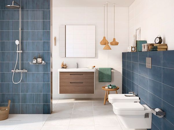 Un baño con azulejos azules, lavabo, inodoro y ducha.