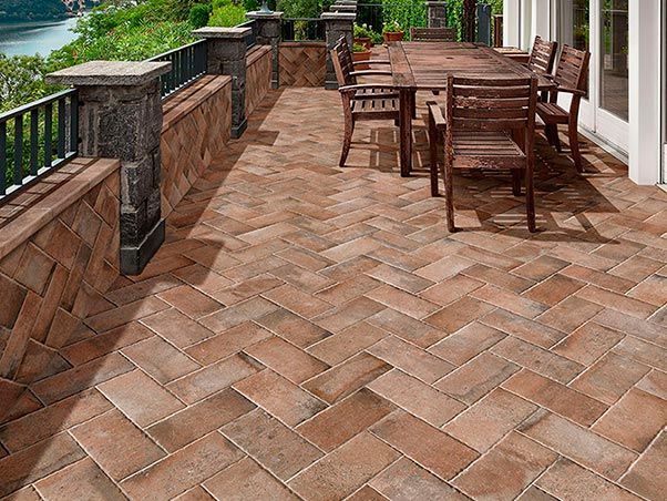 Un patio con una mesa y sillas y un río al fondo.