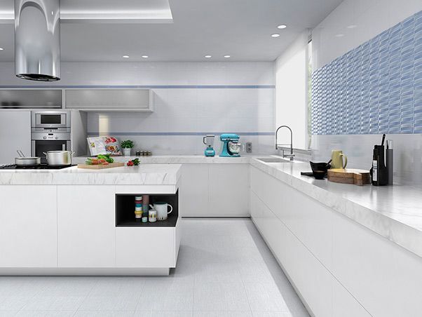 Una cocina moderna con gabinetes blancos y azulejos azules.