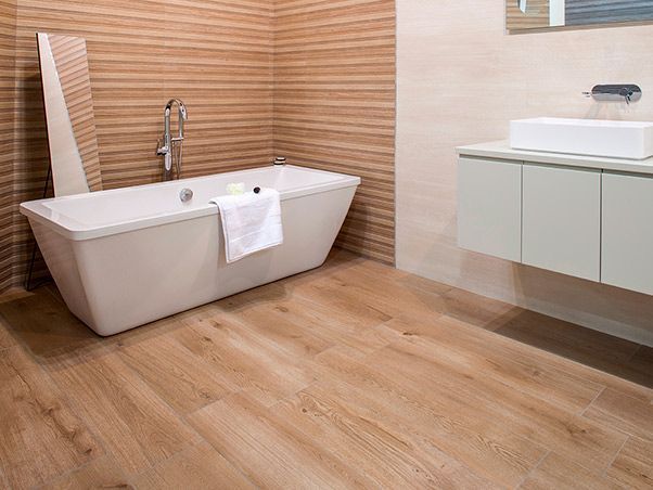 Un baño con bañera, lavabo y espejo.