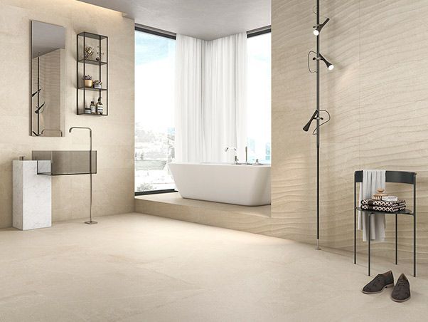 Un baño con bañera, lavabo, espejo y silla.