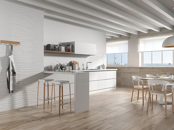 Una cocina con gabinetes blancos y pisos de madera.