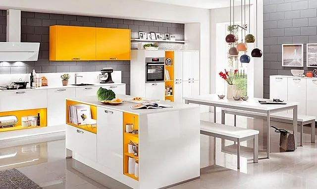 Una cocina con gabinetes amarillos, gabinetes blancos, una mesa y bancos.