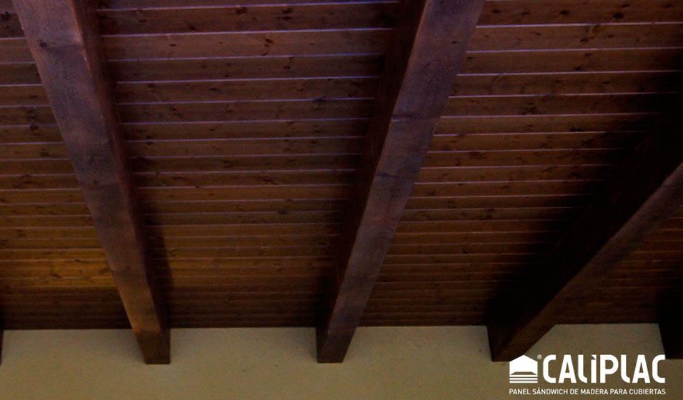 Un techo de madera con el logotipo de Caliplac en la esquina.