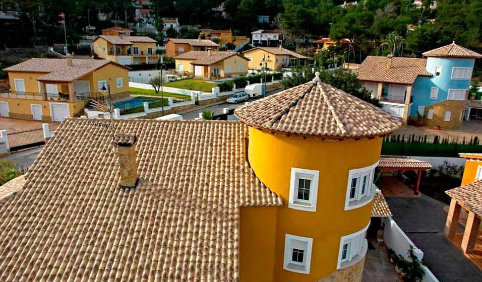 Vista aérea de una casa amarilla con techo de tejas.