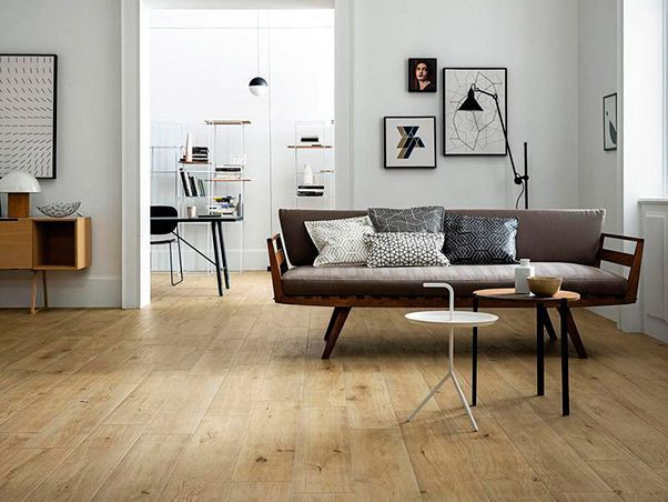 Hay un sofá y dos mesas en la sala de estar.