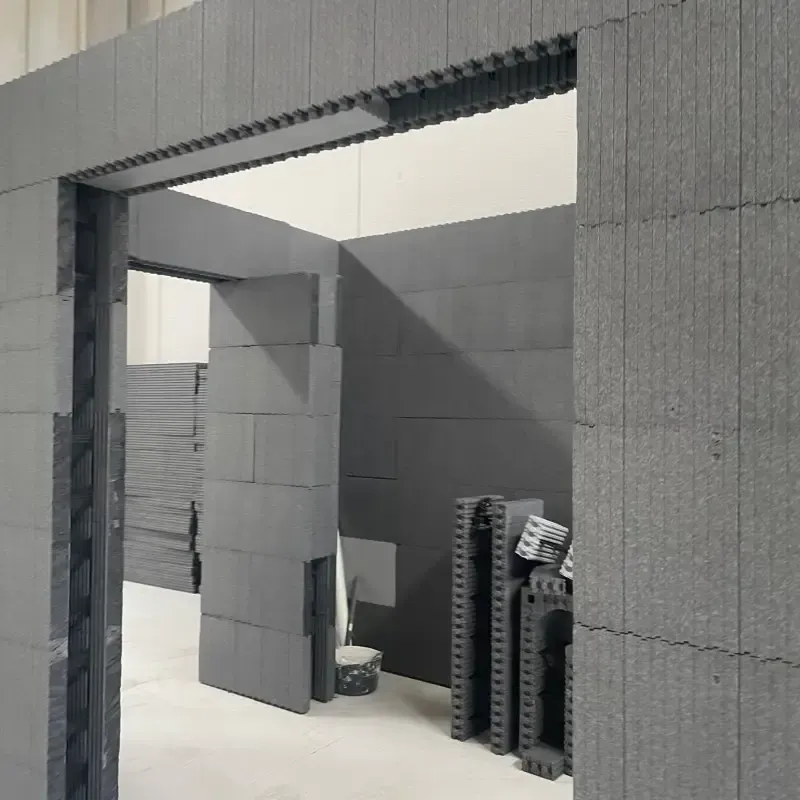 Maqueta arquitectónica gris con una gran abertura rectangular y bloques apilados en una habitación minimalista.