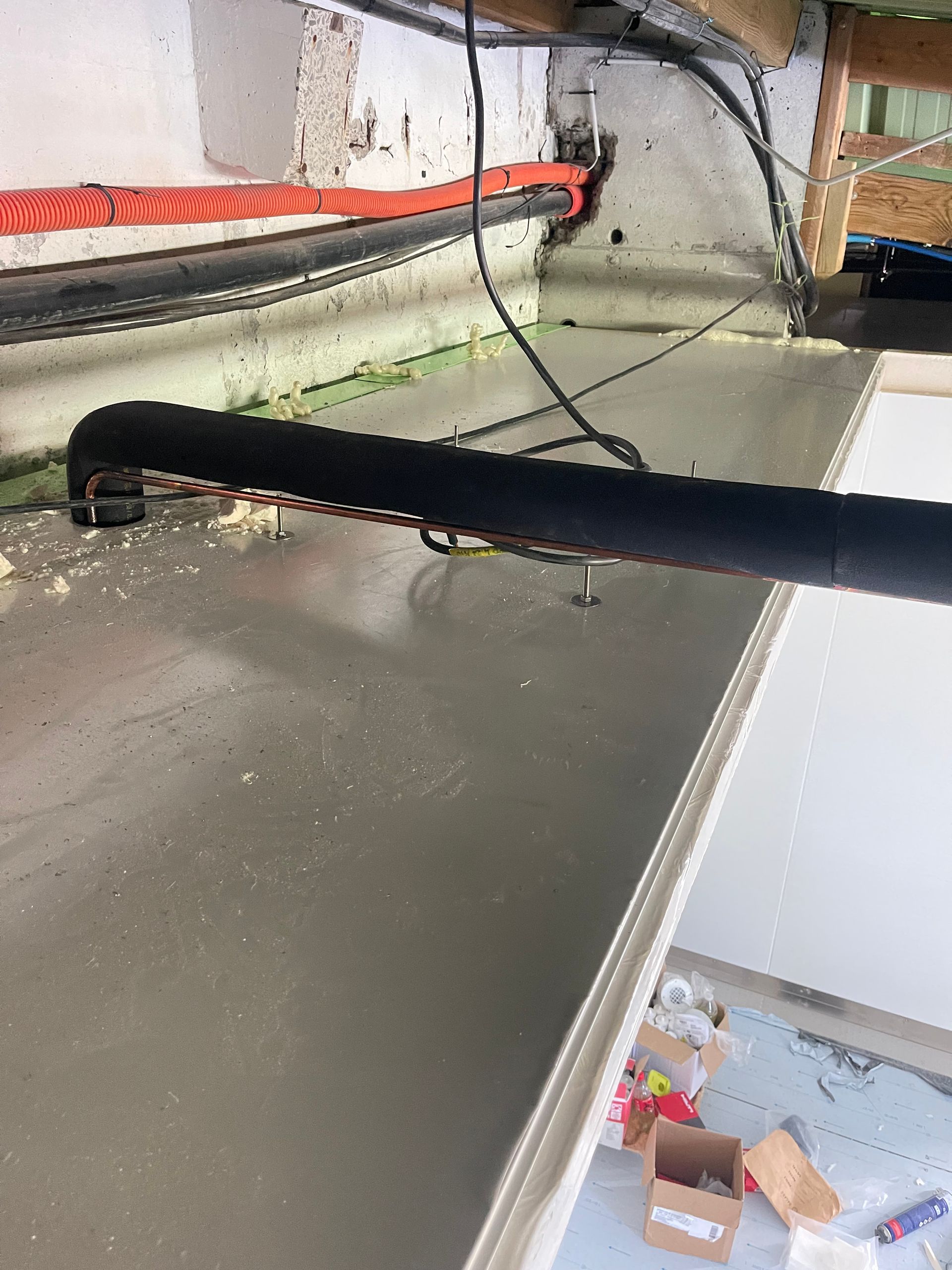 Un ouvrier utilise un marteau pour placer un bloc de béton contre une barre d'armature métallique.