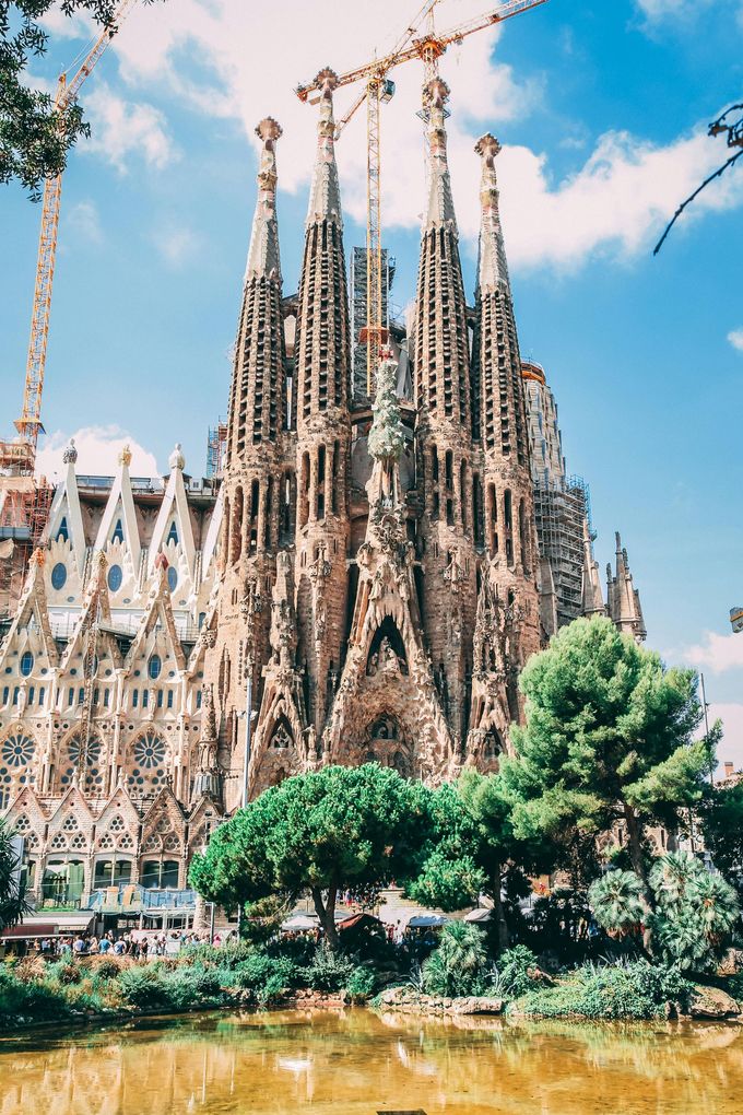 Una gran catedral está rodeada de árboles y un cuerpo de agua.