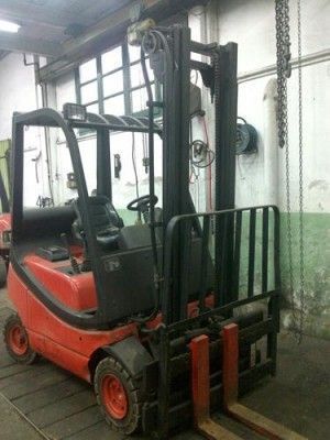 Una carretilla elevadora roja está estacionada en un garaje.