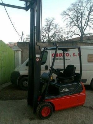 Una carretilla elevadora está estacionada frente a una camioneta blanca que dice caelto s.