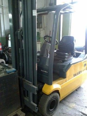 Una carretilla elevadora amarilla y negra está estacionada en un garaje.