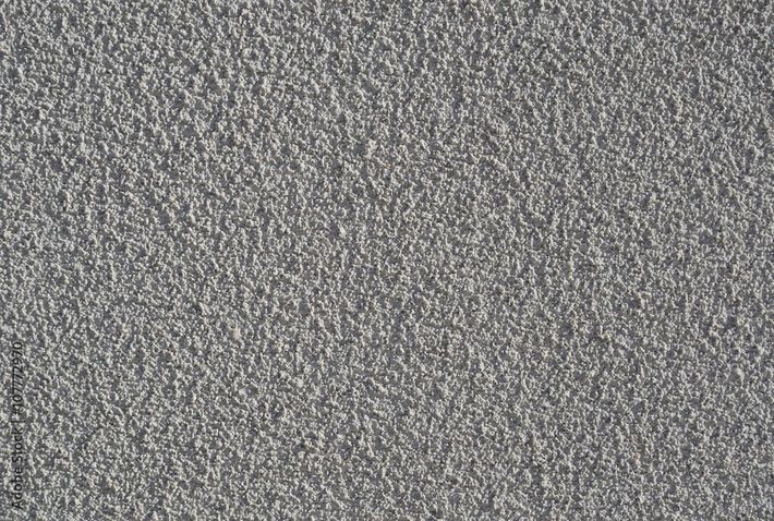 Mur en stuc gris avec surface texturée.