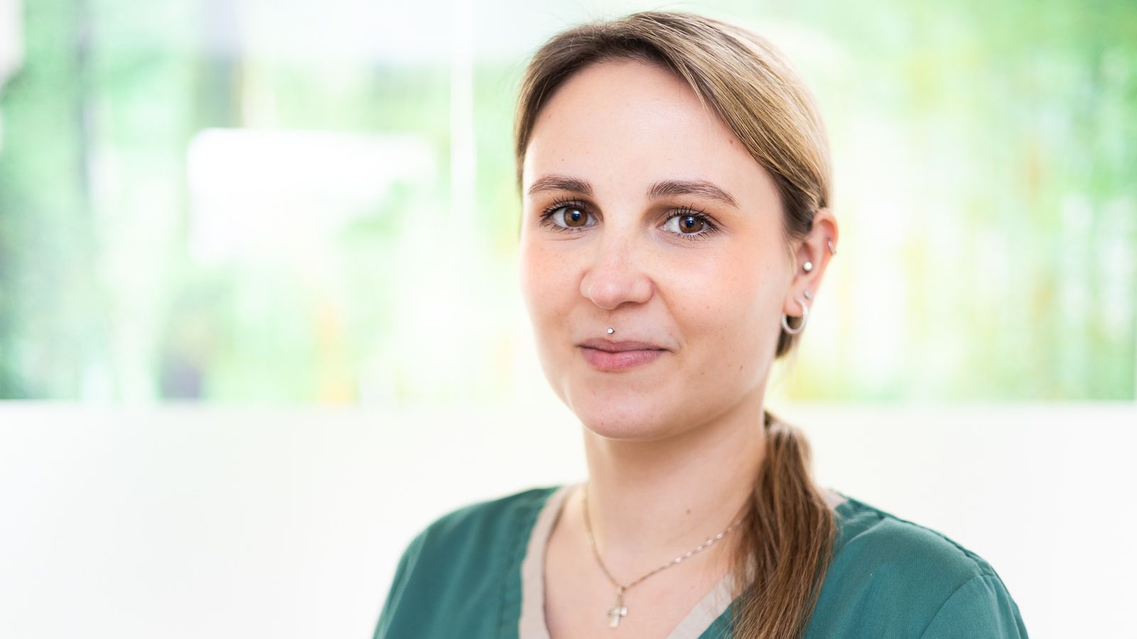 Eine Frau mit Brille und Kasack blickt in die Kamera.