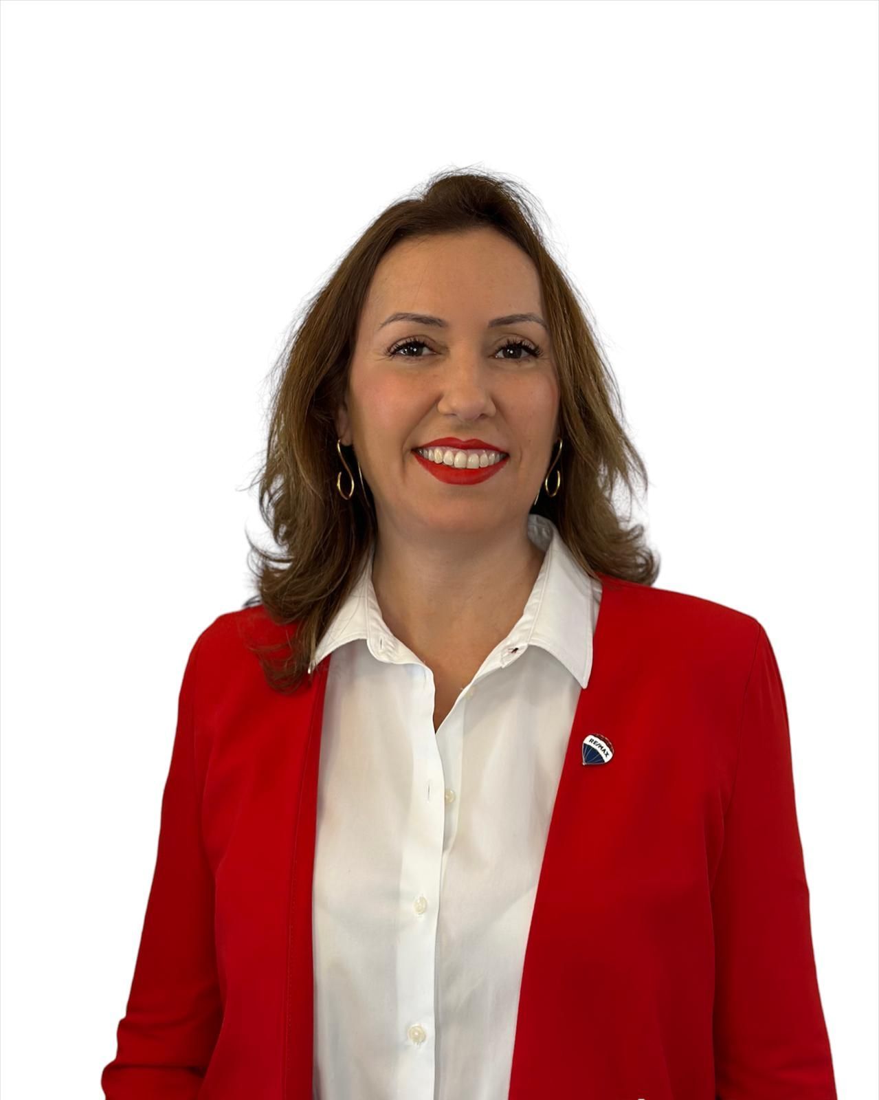 Una mujer que lleva un chaleco y una camisa blanca está sonriendo.