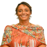 Una mujer que lleva una bufanda sonríe para la cámara.