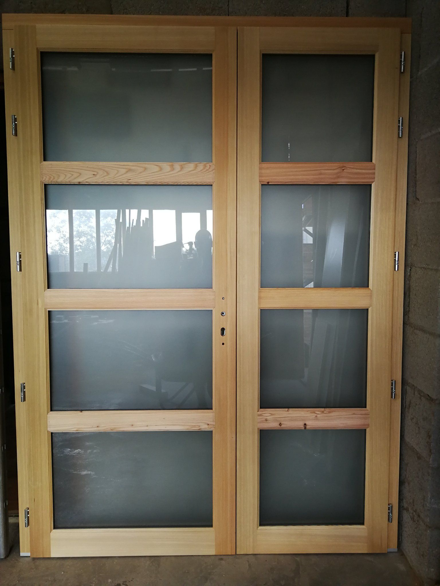 Deux portes doubles en bois avec vitres.