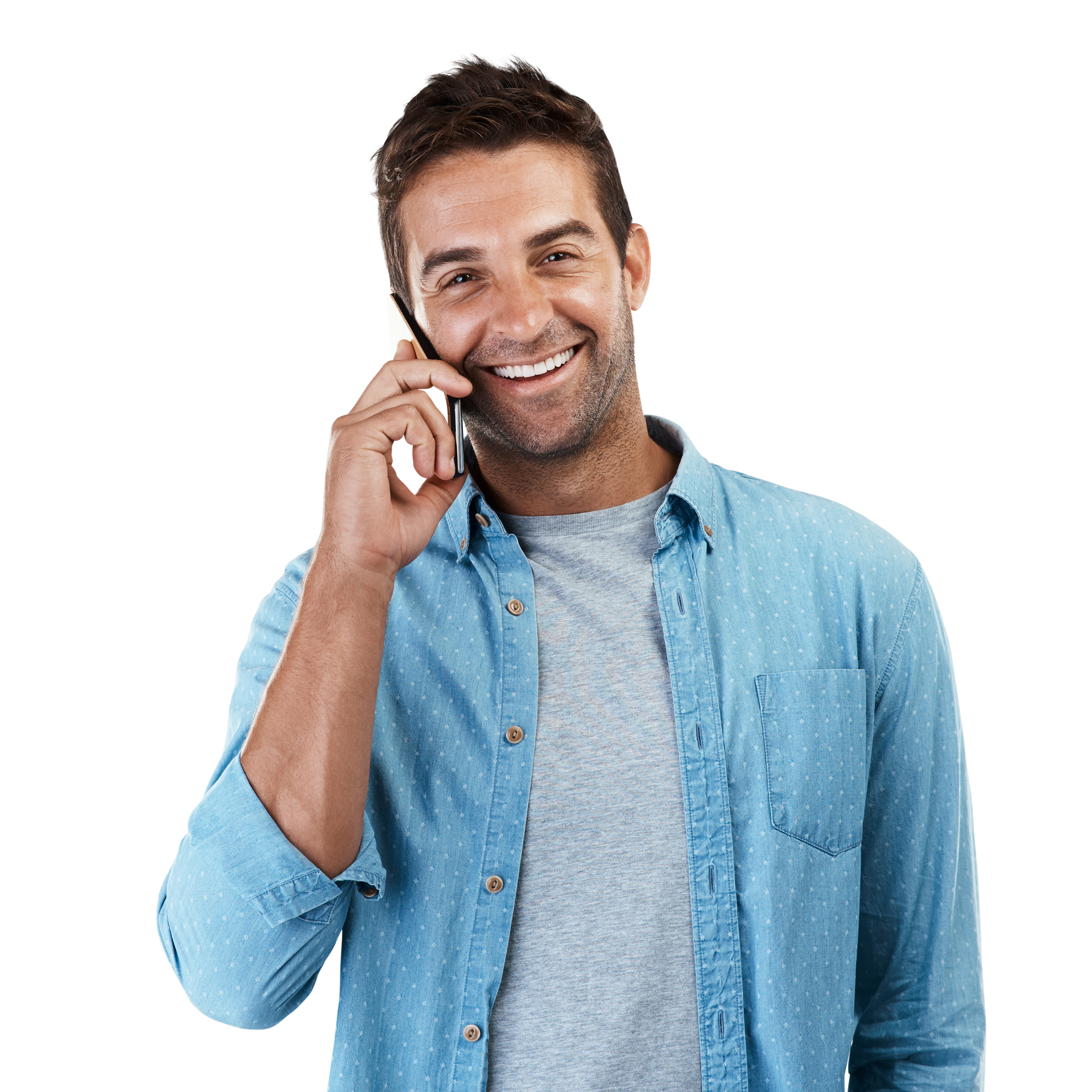 Un homme sourit en parlant au téléphone, portant une chemise bleue.